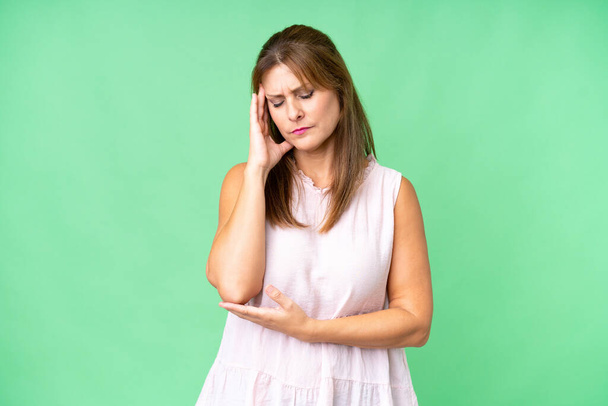 Middelbare leeftijd vrouw over geïsoleerde achtergrond met hoofdpijn - Foto, afbeelding