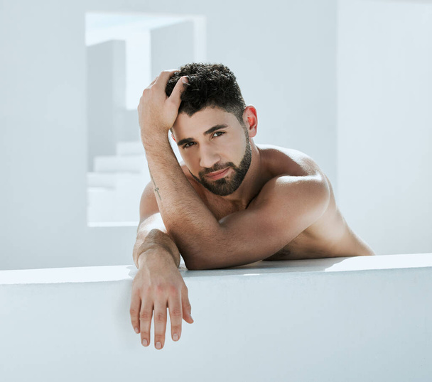 Handsome, building and shirtless man outside in a modern bathroom for creativity and commercial model. Guy, body and artistic person relax, young and calm in a white room relaxing or chilling. - Fotografie, Obrázek