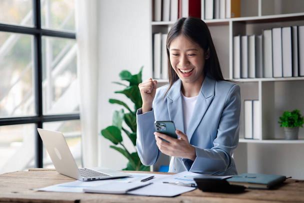 A businesswoman is checking company financial documents and using a tablet to talk to the chief financial officer through a messaging program. Concept of company financial management. - Foto, Imagem