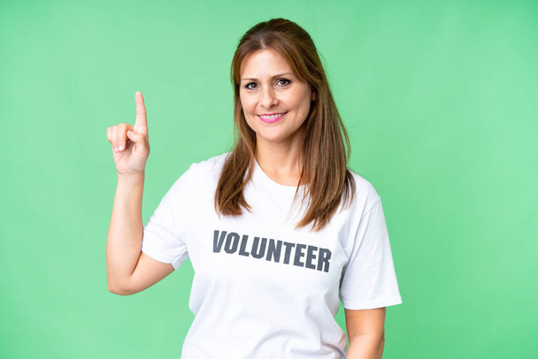 Donna volontaria di mezza età su sfondo isolato mostrando e alzando un dito nel segno del meglio - Foto, immagini