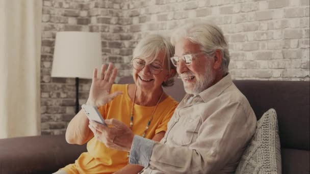 filmy z piękną romantyczną parą seniorów podejmowania rozmowy wideo ze smartfonem - Materiał filmowy, wideo