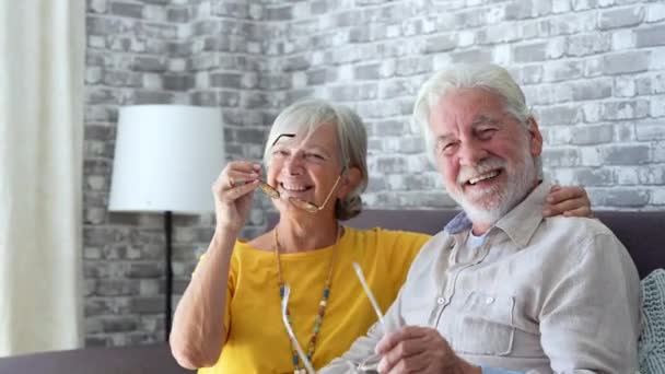 πλάνα από όμορφο ρομαντικό ζευγάρι ηλικιωμένων χαλαρώνοντας στον καναπέ στο σπίτι - Πλάνα, βίντεο