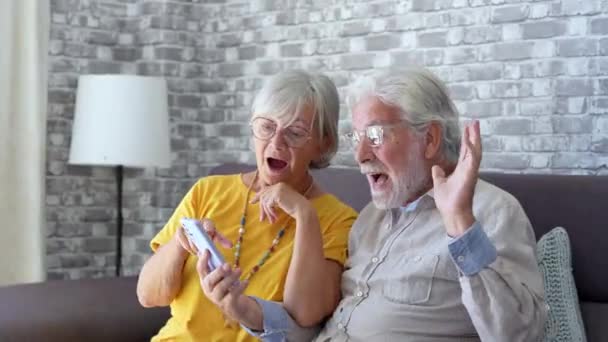 πλάνα από όμορφο ρομαντικό ζευγάρι ηλικιωμένων που κάνει βιντεοκλήση με smartphone - Πλάνα, βίντεο