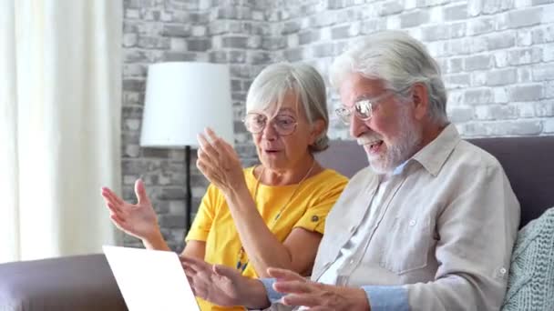 záběry krásné romantické starší pár pomocí notebooku společně na gauči doma - Záběry, video