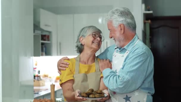 riprese di una bella coppia di anziani che cucinano insieme in cucina - Filmati, video
