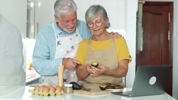 riprese di una bella coppia di anziani che cucinano insieme in cucina - Filmati, video