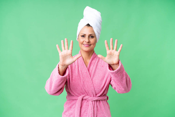 Middle age caucasian woman in a bathrobe over isolated background counting ten with fingers - Photo, Image