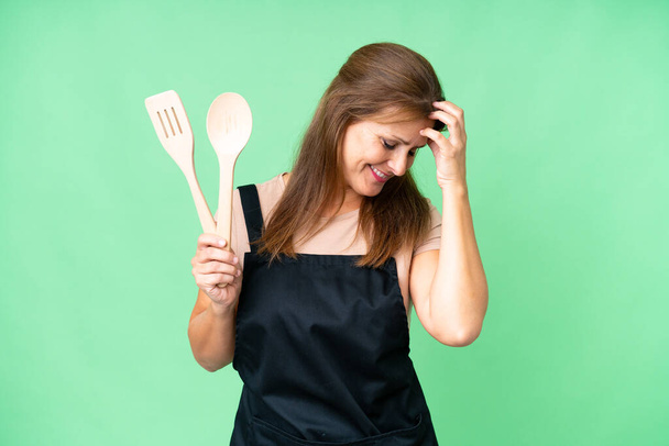 Middle age caucasian woman holding a rolling pin over isolated background laughing - Photo, image