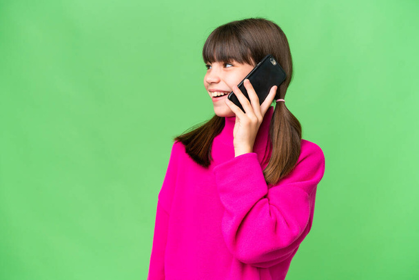 mała kaukaska dziewczyna na odosobnionym tle prowadzenie rozmowy z telefon komórkowy z kimś - Zdjęcie, obraz