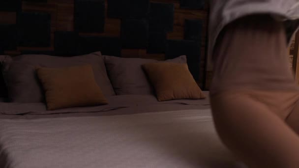 šťastná mladá žena skákání na posteli odpočinku po úspěšném cestování těší nezávislý životní styl svobody v hotelovém pokoji - Záběry, video