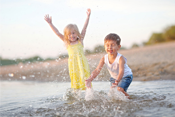 Portrait of a boy and girl on the beach in summer - Φωτογραφία, εικόνα