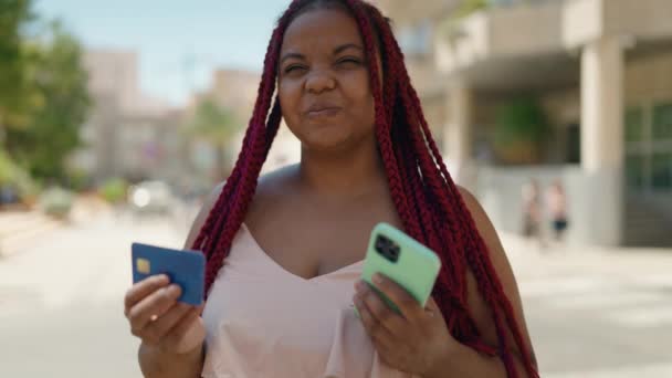 African american woman using smartphone and credit card at street - Πλάνα, βίντεο