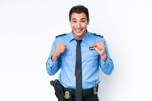 Νεαρός λευκός αστυνομικός, απομονωμένος σε λευκό φόντο, γιορτάζει τη νίκη του στη θέση του νικητή. - Φωτογραφία, εικόνα