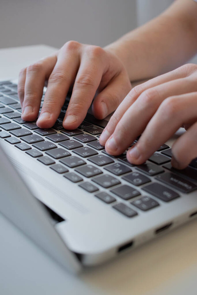 Το χέρι ενός άντρα χρησιμοποιεί ένα trackpad, χρησιμοποιώντας ένα touchpad σε ένα laptop, ένας επιχειρηματίας εργάζεται πληκτρολογώντας σε ένα laptop. - Φωτογραφία, εικόνα