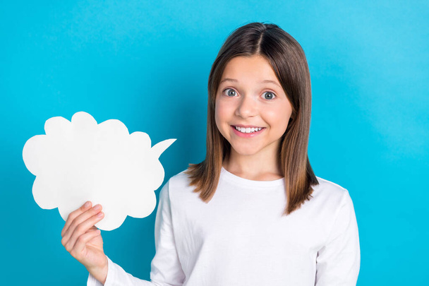 Photo of good mood cheerful schoolgirl with straight hairdo dressed white shirt holding mind cloud isolated on blue color background. - Foto, immagini
