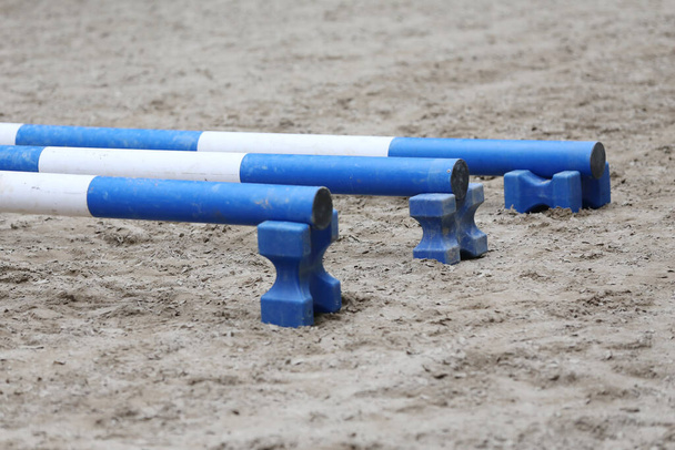 Show jumping poles obstacles, barriers, waiting for riders on show jumping training. Horse obstacle course outdoors summertime. Poles in the sand at equestrian center outdoors - Photo, Image
