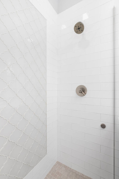 A bathroom's walk-in shower with white subway and grey arabesque tiles on the walls. - Photo, Image