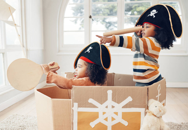 Pirát, box a hraní si s dětmi v obývacím pokoji pro sblížení, představivost a kreativitu. Happy, mládež a sourozenci s dívkami plachtění v lepenkové lodi v rodinném domě pro relaxaci, fantazie a hry. - Fotografie, Obrázek