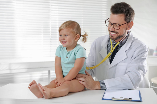Pediatrician examining baby with stethoscope in clinic - Foto, Imagem
