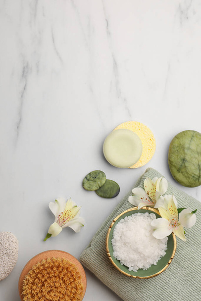 Flat lay composition with spa products and flowers on white marble table. Space for text - Foto, afbeelding