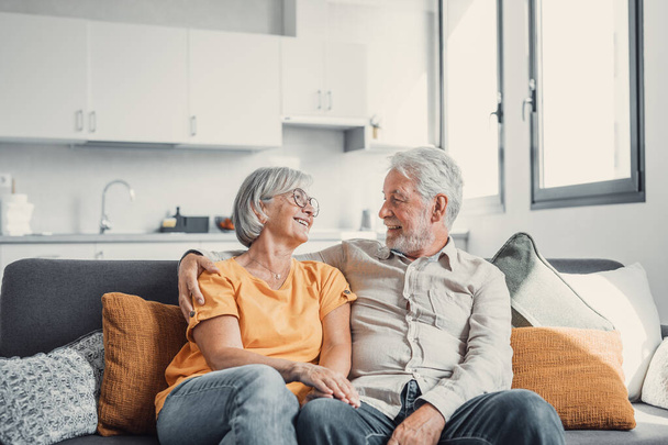 Happy laughing older married couple talking, laughing, standing in home interior together, hugging with love, enjoying close relationships, trust, support, care, feeling joy, tenderness - Foto, Imagem