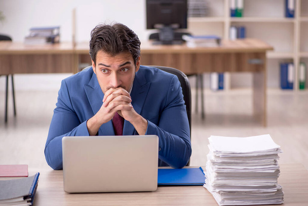 Young businessman employee and too much work at workplace - Photo, Image