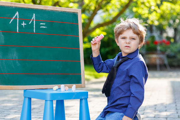 Little boy at blackboard learning to write - Photo, Image
