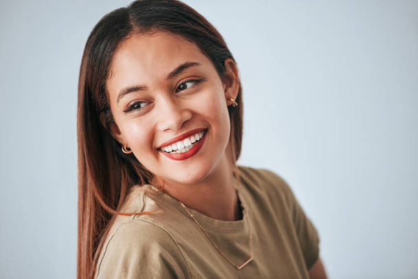 Woman, smile and happiness of a gen z female in a studio with gray background. Isolated, happy and beauty from a young person feeling carefree, relax youth and confidence with female empowerment. - Foto, imagen