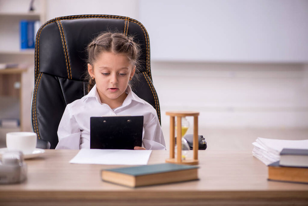 Little girl sitting in the classroom in time management concept - Foto, imagen