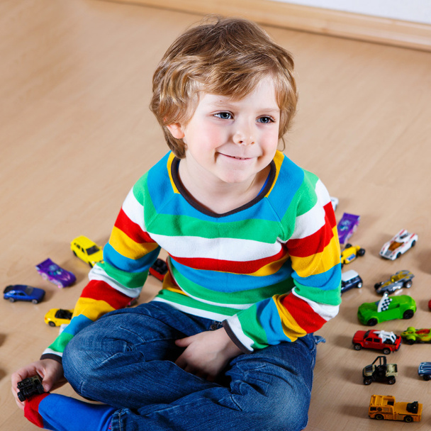 Vicces kis fiú játék rengeteg játékszert autók fedett - Fotó, kép