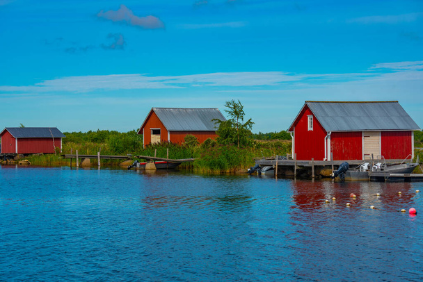 Red timber boat houses at Svedjehamn in Finland. - Foto, afbeelding
