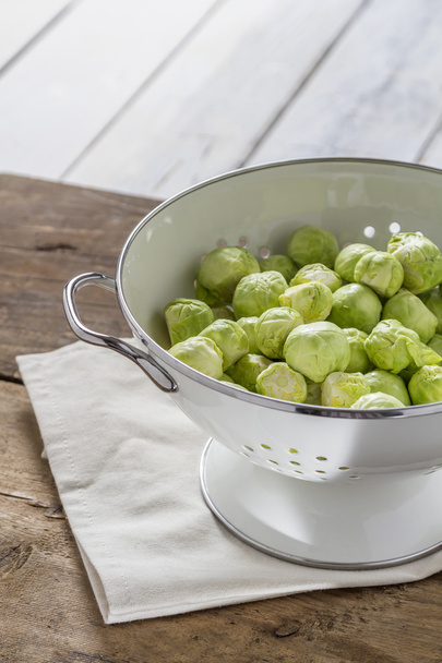 Brussels sprouts in a sieve on a table - Photo, Image