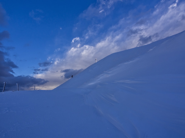 Hiker reaching the frozen summit cross of mount Catria in winter, Apennines, Italy - Fotoğraf, Görsel