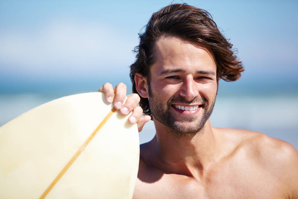 Heading to the water. An attractive young man about to go surfing - Foto, Imagem