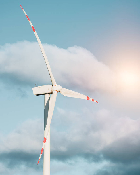 Одна турбинная мельница. Ветряная турбина в зеленом поле против голубого неба с пушистыми облаками. Концепция зеленой энергетики и устойчивого будущего. - Фото, изображение