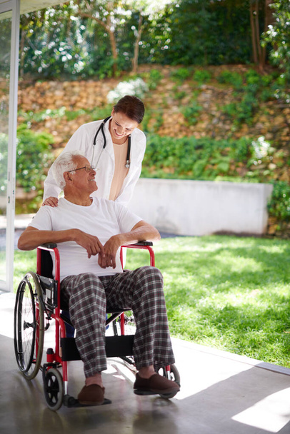 Positive support for senior patients. Full length shot of a senior man in a wheelchair talking to his doctor - Foto, Bild