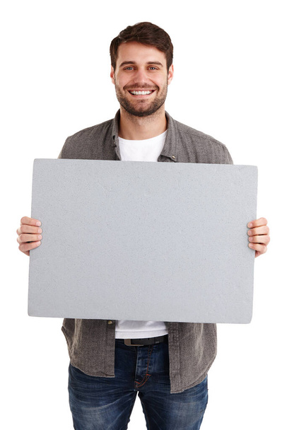 Im proud of this message. Studio portrait of a smiling young man holding up a blank poster - Photo, Image