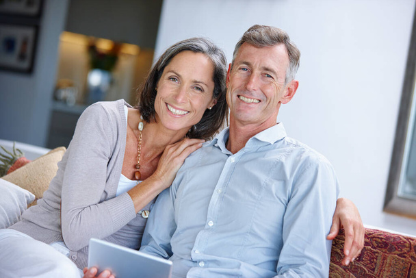 Relaxing together at home. a loving mature couple using a digital tablet at home - Photo, Image