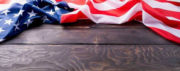 Dzień Pamięci USA, Dzień Prezydenta, Dzień Weterana, Dzień Pracy lub obchody 4 lipca. Zbliżenie amerykańskiej flagi na ciemnym drewnianym tle - Zdjęcie, obraz