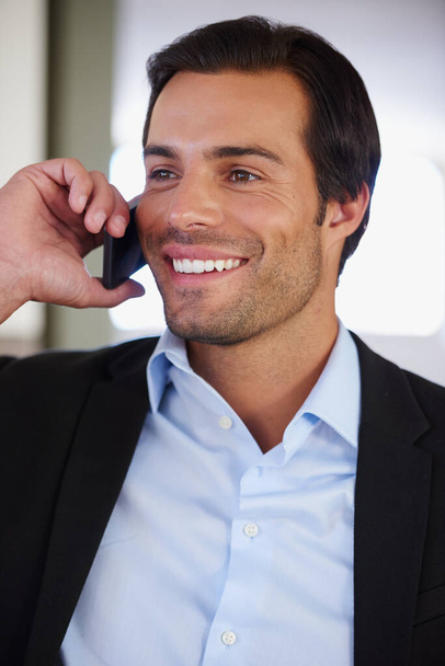 Cieszę się, że mogłem pomóc. przystojny biznesmen uśmiechnięty podczas rozmowy przez telefon - Zdjęcie, obraz