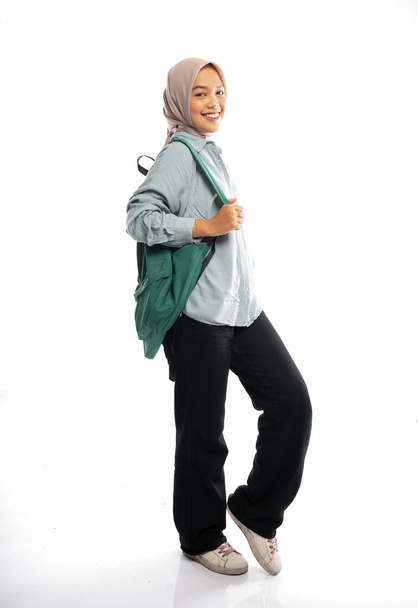 portrait of Asian Muslim student in hijab walking with backpack in isolated background - Foto, Imagem