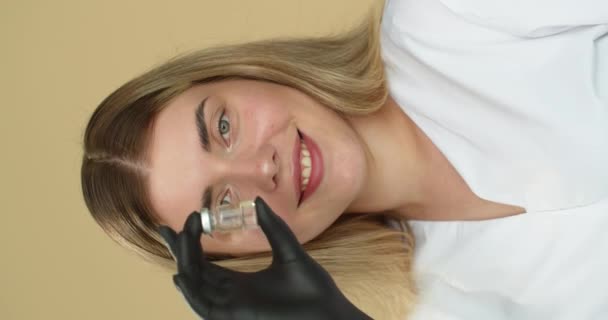 Primo piano di un volto medico che presenta un flaconcino con un vaccino in mano. Industria farmaceutica. - Filmati, video