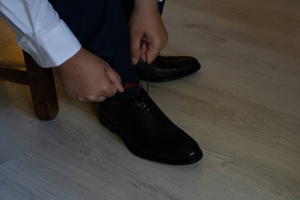 man lacing shoes on wedding day - 写真・画像