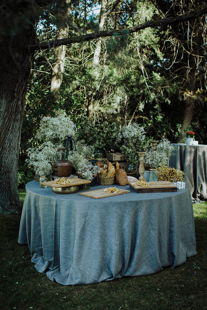 vintage style rustic wooden table with flowers and bread - Photo, Image