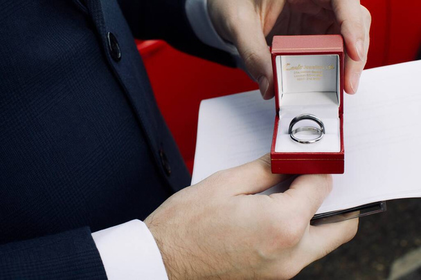 noivo segurando anéis de casamento
 - Foto, Imagem