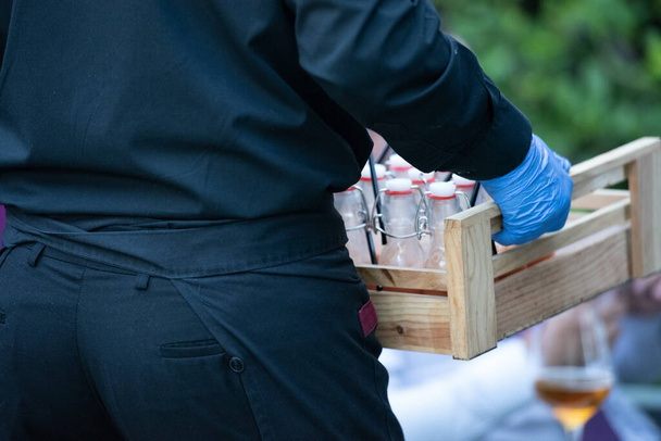 waiter carrying box with water bottles  - Photo, image