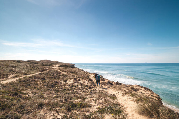 Gli avventurieri appassionati camminano lungo la costa aspra e asciutta con scogliere intorno all'Oceano Atlantico su un sentiero chiamato Fisherman Trail in Portogallo.. - Foto, immagini