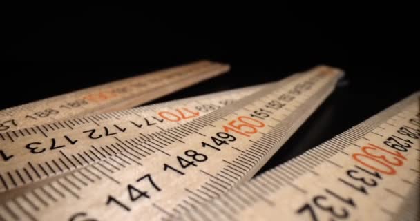 木製の定規は、黒の背景にセンチメートルとミリメートルでマーク。インデント印刷されたスケールコンセプト - 映像、動画