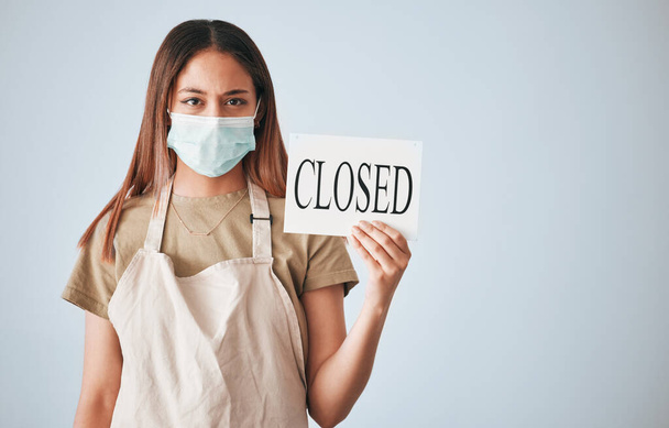 Woman, closed sign and face mask for covid in studio for announcement isolated on white background mockup. Entrepreneur, small business owner and closing poster for pandemic with portrait of waitress. - Photo, image
