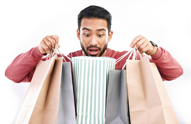 Sale, wow and shocked man with shopping bag in studio, excited for discount or purchase on white background. Deal, omg and indian guy with product from shop, mall or market while posing isolated. - Photo, Image